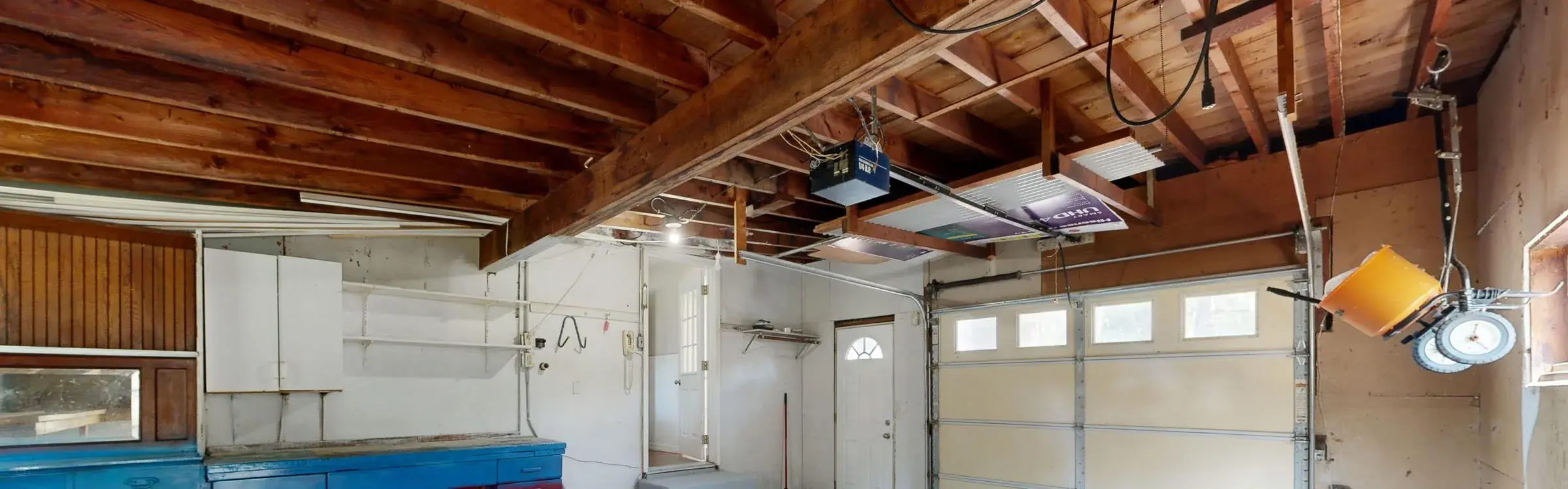 A garage ceiling with an electric opener motor and its rail running to the door header.